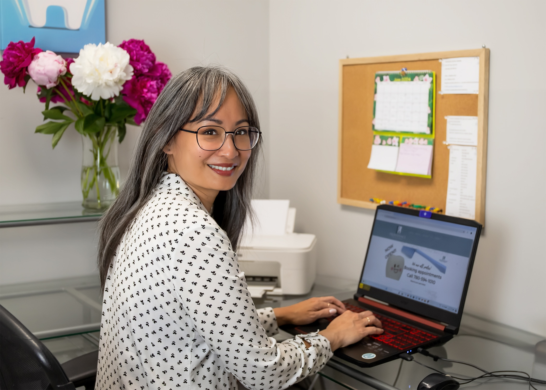 Jeamie Nichol sitting at the reception desk typing on a computer